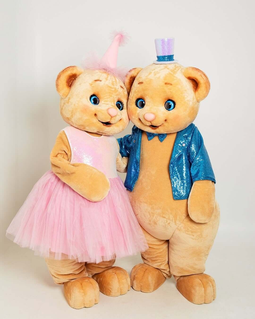 Two teddy bear mascots in blue and pink hugging at a children’s event in Espoo, Uusimaa, Finland.