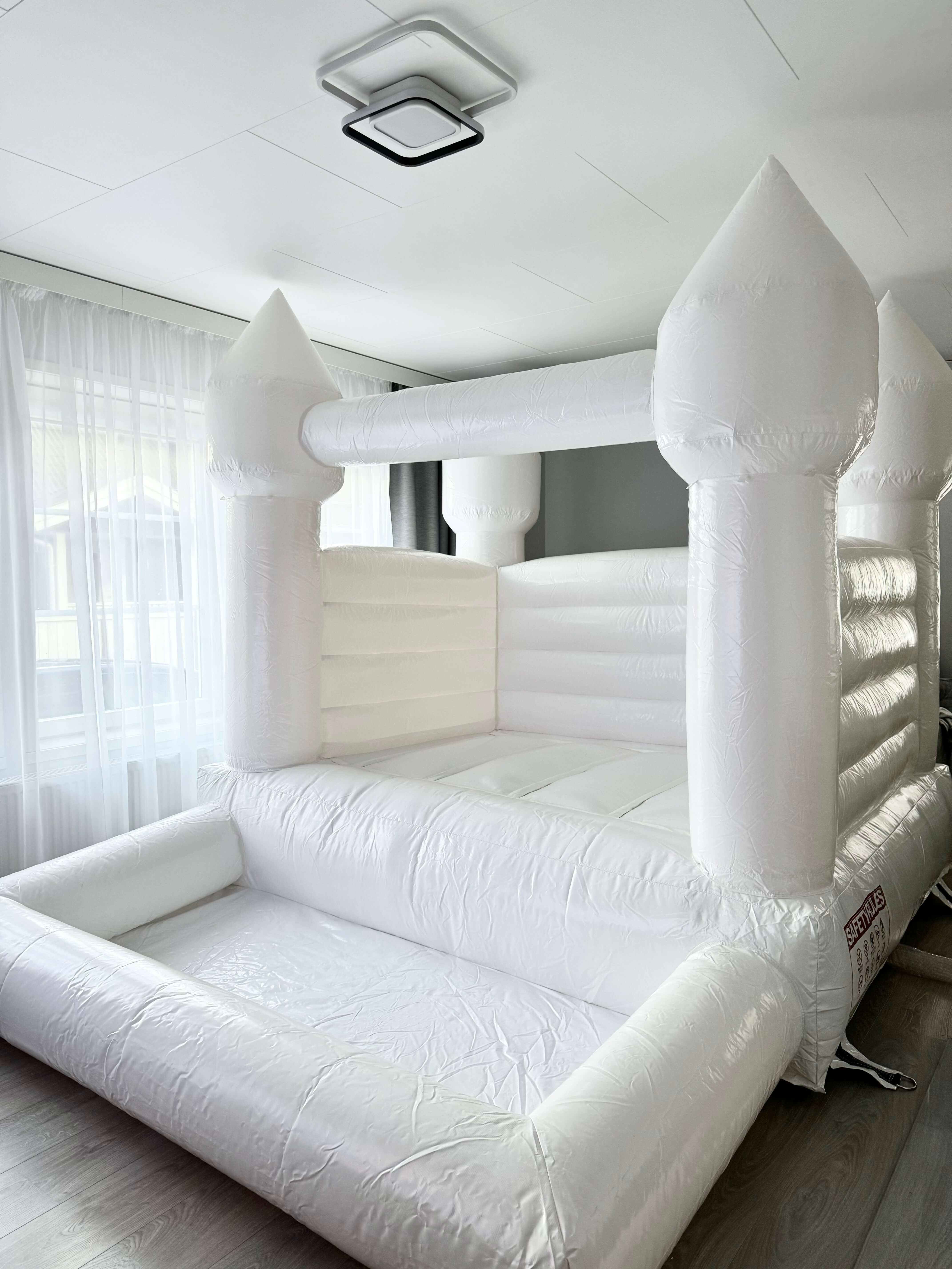 White inflatable bounce house with ball pit – available for party rental in Espoo, Uusimaa, Finland.